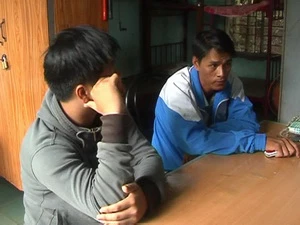 Hai đối tượng hành hung phóng viên tại trụ sở Công an. (Ảnh: Sỹ Tuyên/Vietnam+)