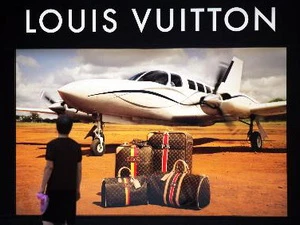 Một người đàn ông bên ápphích quảng cáo bên ngoài cửa hàng Louis Vuitton mới khai trương ở Phúc Châu. (Nguồn: THX/TTXVN)