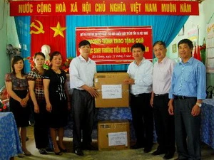 Ông Đỗ Cường, Phó Tổng Biên tập Báo Điện tử VietnamPlus, Chủ tịch Hội Cựu chiến binh - TTXVN trao tặng quà cho trường Tiểu học B Minh Tân. (Ảnh: Minh Tâm/Vietnam+)