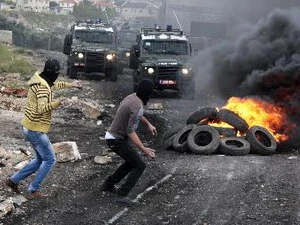 Người biểu tình Palestine ném đá vào binh sỹ Israel tại làng Kufr Qadoom. (Nguồn: THX/TTXVN)