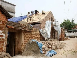 Sửa chữa nhà tại làng cổ Đường Lâm. (Ảnh: Nhật Anh/TTXVN)