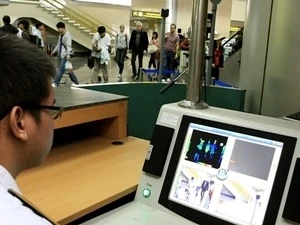 Nhân viên tại Sân bay quốc tế Nội Bài theo dõi thân nhiệt hành khách bằng máy đo tia hồng ngoại. Ảnh minh họa. (Ảnh: Dương Ngọc/TTXVN)