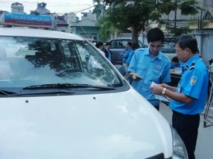 Lực lượng Thanh tra đang tiến hành kiểm tra xe taxi. (Ảnh: Việt Hùng/Vietnam+)