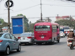Xe khách vẫn mở cửa "vợt" khách dọc đường Kim Đồng, Giải Phóng. (Ảnh: Việt Hùng/Vietnam+)
