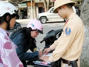 Lực lượng Cảnh sát giao thông xử phạt người vi phạm. (Ảnh: Vietnam+)