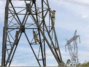 Các công nhân đang kiểm tra, khắc phục sự cố đường dây điện. (Ảnh: TTXVN)