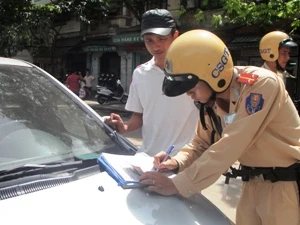 Lực lượng Cảnh sát giao thông tiến hành xử phạt xe taxi vi phạm. (Ảnh: Việt Hùng/Vietnam+)
