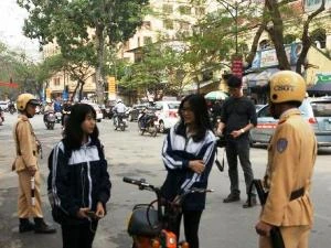 Lực lượng Cảnh sát giao thông xử lý học sinh đi xe đạp điện phạm Luật Giao thông. (Ảnh: Việt Hùng/Vietnam+)