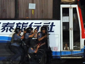 Lực lượng đặc nhiệm áp sát chiếc xe bị bắt cóc để giải thoát cho các con tin. (Nguồn: AFP/TTXVN) 