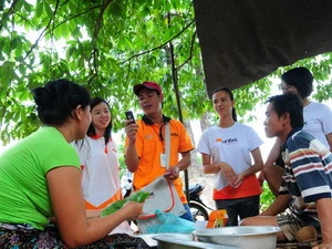 Cán bộ nhân viên Viettel tổ chức bán hàng tại một làng của Lào. (Ảnh: PV/Vietnam+)