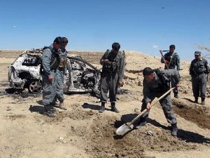 Cảnh sát Afghanistan bên chiếc xe bị phá hủy trong cuộc không kích của NATO ở Ghazni ngày 30/3. (Nguồn: AFP/TTXVN) 
