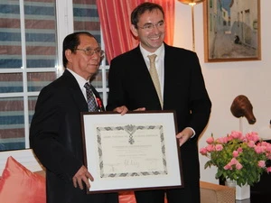 Đại sứ Pháp tại Việt Nam Poirier đã trao Huân chương cho ông Trịnh Ngọc Thái. (Ảnh: PV/Vietnam+)