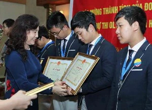 Thứ trưởng Bộ Giáo dục và Đào tạo Nguyễn Thị Nghĩa trao Bằng khen của Bộ cho các học sinh đoạt giải. (Ảnh: Quý Trung/TTXVN)