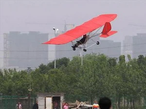 Máy bay của Thư Mãn Sinh lượn trên không trung trước con mắt thán phục của người dân trong vùng. (Nguồn: Chinadaily)