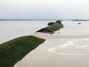 Nước lũ chảy qua đoạn đê bị vỡ ở tỉnh Giang Tây ngày 22/6. (Nguồn: Getty Images)