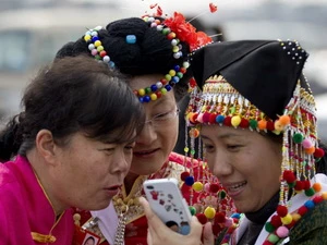 Người dân tộc thiểu số Trung Quốc xem ảnh qua smartphone tại Bắc Kinh. Ảnh minh họa. (Nguồn: AP)
