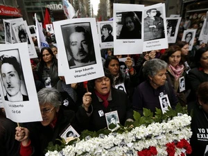 Người tuần hành mang theo ảnh người thân là nạn nhân của chế độ độc tài Pinochet. (Nguồn: Reuters)