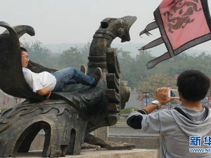 Khách du lịch trèo lên các biểu tượng lịch sử để chụp ảnh lưu niệm. (Nguồn: news.cn)