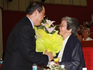 Phó Thủ tướng Nguyễn Thiện Nhân tặng hoa cụ bà Hoàng Kim Anh, vợ cố Giáo sư Tạ Quang Bửu. (Ảnh: Phạm Mai/Vietnam+).