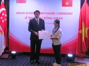 Đại sứ Singapore Ng Teck Hean trao học bổng cho các em học sinh. (Ảnh: Phạm Mai/Vietnam+)