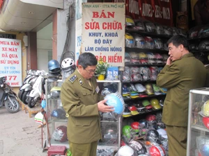 Quản lý thị trường Hà Nội kiểm tra mũ bảo hiểm trên tuyến phố Huế (Ảnh: Đức Duy/Vietnam+)
