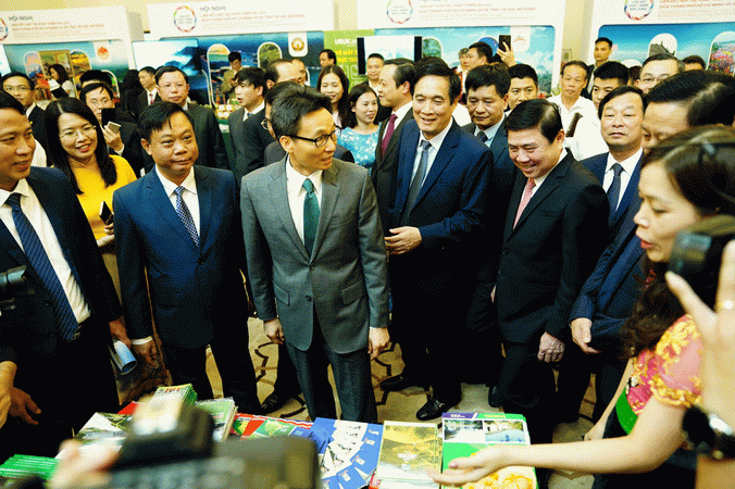 Phó Thủ tướng Vũ Đức Đam và Chủ tịch UBND TPHCM Nguyễn Thành Phong cùng các đại biểu tham quan khu trưng bày tại Hội nghị. (Nguồn: sggp.org.vn)
