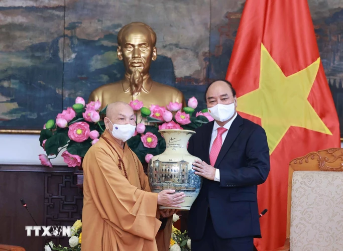 Chủ tịch nước Nguyễn Xuân Phúc tặng quà lưu niệm cho Hội đồng Trị sự Trung ương Giáo hội Phật giáo Việt Nam. (Ảnh: Thống Nhất/TTXVN)
