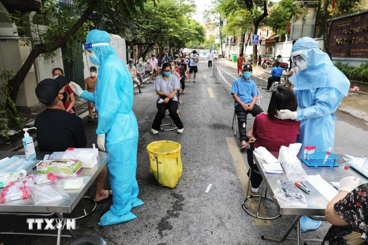 Nhân viên y tế lấy mẫu xét nghiệm cho toàn bộ người dân tại ngõ phố Cao Đạt, phường Lê Đại Hành, quận Hai Bà Trưng, ngày 13/8. (Ảnh: Thành Đạt/TTXVN)