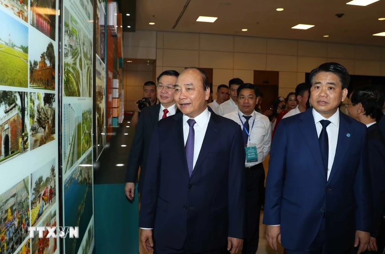 Thủ tướng Nguyễn Xuân Phúc và các đại biểu tham quan các gian trưng bày bên lề Hội nghị xúc tiến đầu tư Hà Nội 2020. (Ảnh: Thống Nhất/TTXVN)