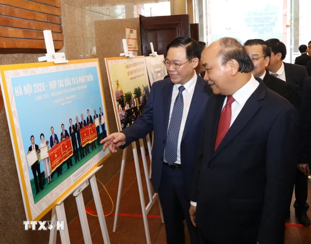 Thủ tướng Nguyễn Xuân Phúc cùng các đại biểu tham quan triển lãm ảnh về kết quả phong trào thi đua yêu nước giai đoạn 2015-2020. (Ảnh: Văn Điệp/TTXVN)