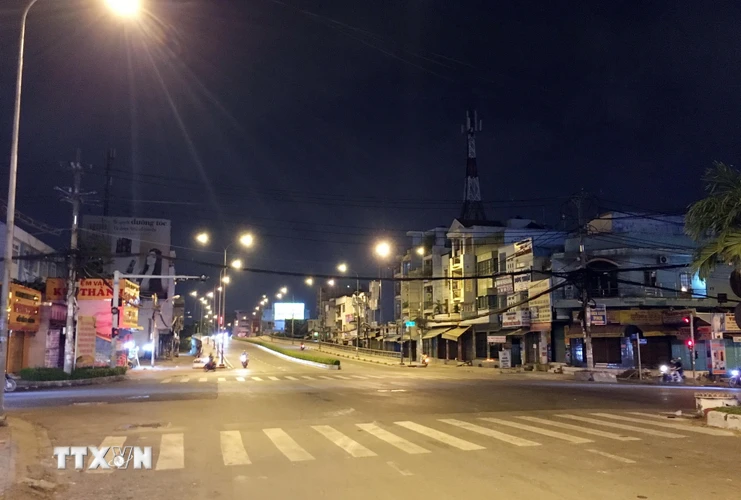 Ngã tư chợ Cầu (nút giao đường Tô Ký-Nguyễn Văn Quá) lúc 22 giờ ngày 30/5, 'cửa ngõ' hướng vào quận Gò Vấp khá vắng vẻ trước giờ giãn cách xã hội. (Ảnh: Tiến Lực/TTXVN)