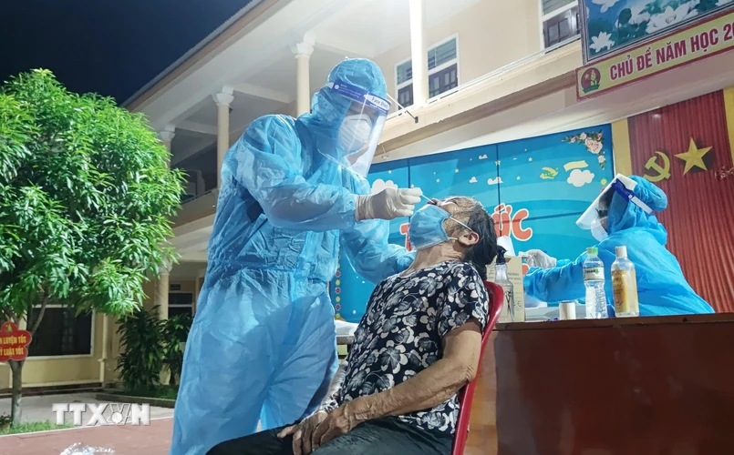 Lực lượng y tế lấy mẫu xét nghiệm COVID-19 cho người dân xã Nghi Ân, thành phố Vinh, tỉnh Nghệ An. (Ảnh: Văn Tý/TTXVN)
