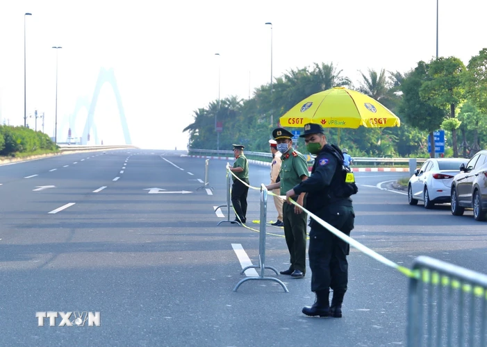 Từ 6h30, lực lượng chức năng lập rào chắn chuẩn bị triển khai chốt từ đường Võ Chí Công lên cầu Nhật Tân. (Ảnh: Hoàng Hiếu/TTXVN)