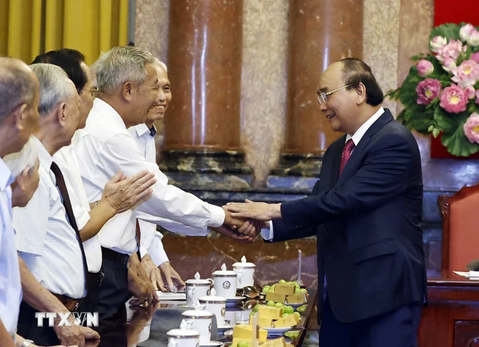 Chủ tịch nước Nguyễn Xuân Phúc với các cán bộ từng phục vụ và bảo vệ Bác Hồ. (Ảnh: Thống Nhất/TTXVN)