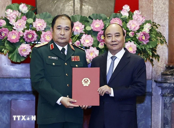 Chủ tịch nước Nguyễn Xuân Phúc trao quyết định thăng quân hàm Thượng tướng cho ông Phùng Sĩ Tấn. (Ảnh: Thống Nhất/TTXVN)