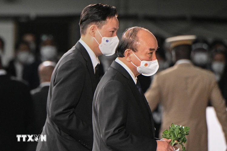 Chủ tịch nước Nguyễn Xuân Phúc (bên phải) đặt hoa tưởng niệm cố Thủ tướng Nhật Bản Abe Shinzo tại Lễ quốc tang ở thủ đô Tokyo, ngày 27/9. (Ảnh: AFP/TTXVN)