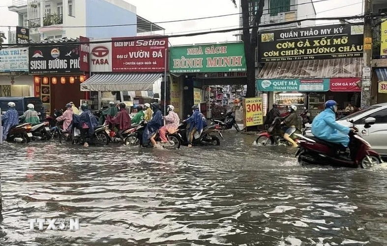 Nước ngập gần nửa bánh xe trên đường Lê Văn Thọ, quận Gò Vấp. (Ảnh: Hồng Giang/TTXVN)