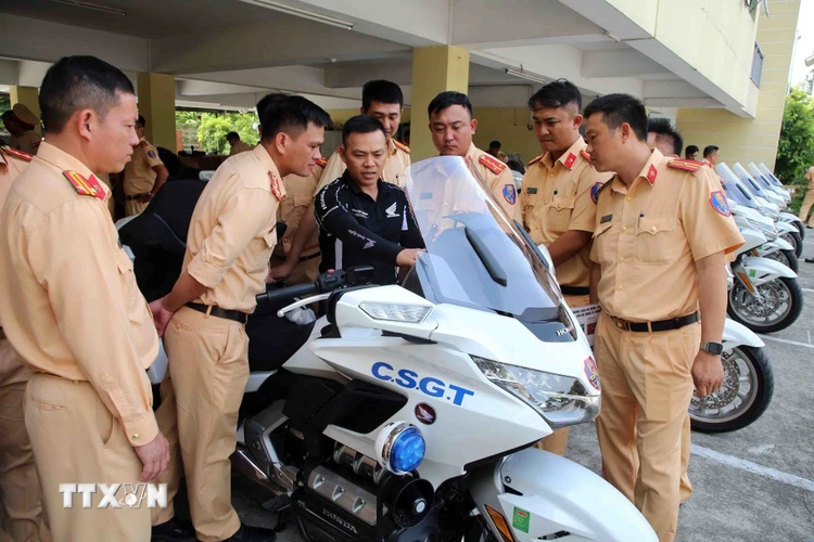 Sau khi được bàn giao, cán bộ chiến sỹ cảnh sát giao thông được tập huấn sử dụng xe. (Ảnh: Phạm Kiên/TTXVN)