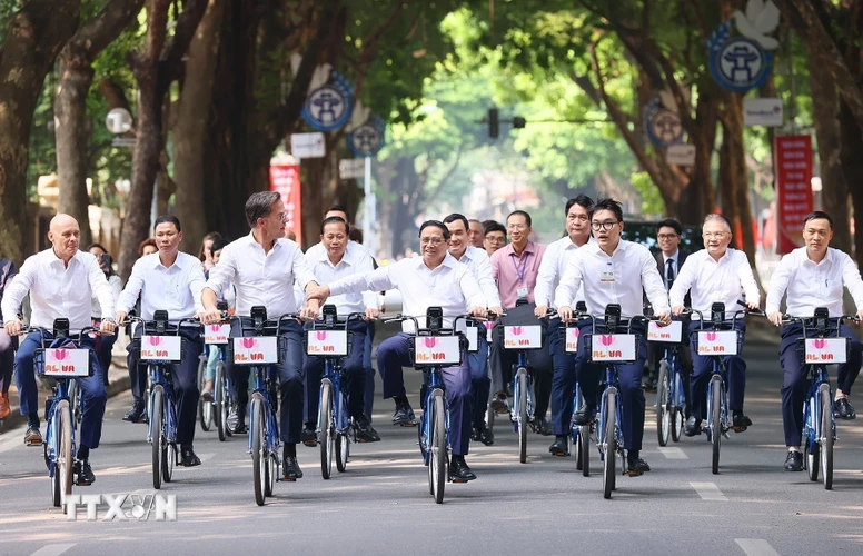 Thủ tướng Phạm Minh Chính cùng Thủ tướng Hà Lan Mark Rutte đạp xe trên phố Phan Đình Phùng. (Ảnh: Dương Giang/TTXVN)