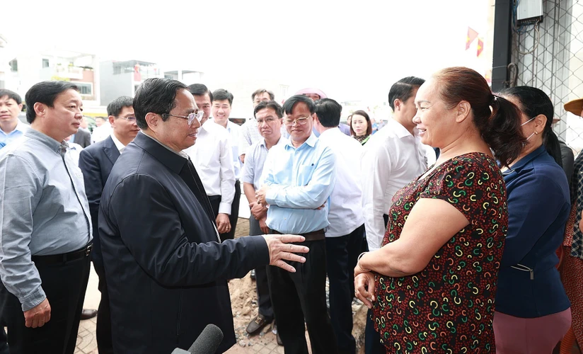 Thủ tướng Phạm Minh Chính trao đổi với người dân Khu tái định cư Dự án Cảng Hàng không Quốc tế Long Thành. (Ảnh: Dương Giang/TTXVN)