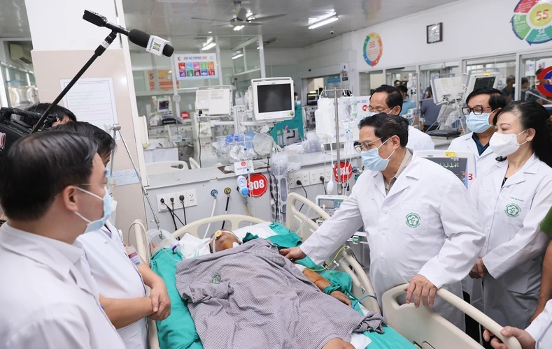 Thủ tướng Phạm Minh Chính thăm hỏi sức khỏe các nạn nhân đang điều trị tại Bệnh viện Bạch Mai. (Ảnh: Dương Giang/TTXVN)