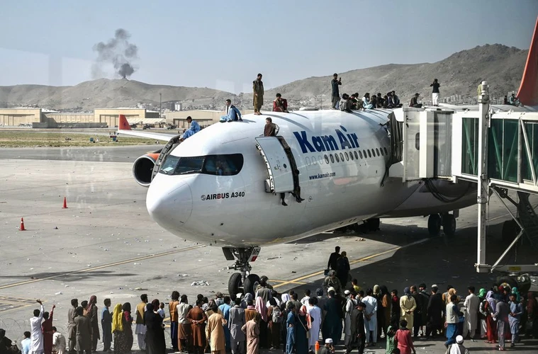 Nhiều người dân Afghanistan đã đu lên nóc máy bay để ngồi chờ được bay.(Nguồn: AFP)