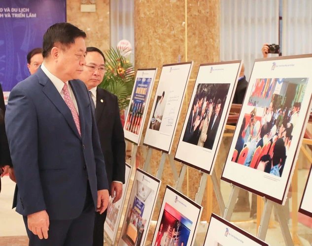 Đồng chí Nguyễn Trọng Nghĩa, Bí thư Trung ương Đảng, Trưởng Ban Tuyên giáo Trung ương cùng các đại biểu tham quan trưng bày ảnh tại lễ kỷ niệm. (Ảnh: Thanh Tùng/TTXVN)