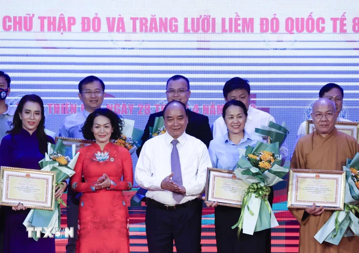Chủ tịch nước Nguyễn Xuân Phúc tặng hoa cho các nhà tài trợ. (Ảnh: Thống Nhất/TTXVN)