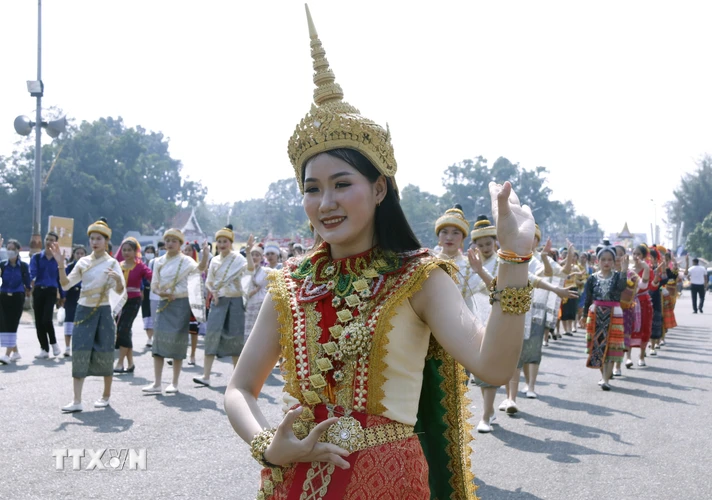 Một thiếu nữ người Lào mặc trang phục truyền thống múa trong lễ rước Pasatpheung (Rước tháp) tại lễ hội Thatluang. (Ảnh: Phạm Kiên-Bá Thành/TTXVN)