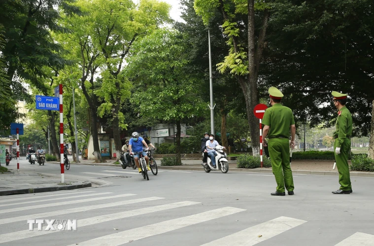 Công an quận Hoàn Kiếm, Hà Nội lập chốt, tuyên truyền người dân ở nhà, hạn chế tối đa ra ngoài tập thể dục khu vực Hồ Hoàn Kiếm. (Ảnh: Doãn Tấn/TTXVN)