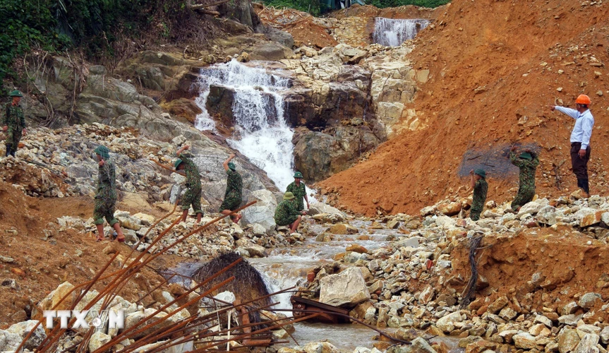 Lực lượng cứu hộ vận chuyển rọ đá để thực hiện nhiệm vụ nắn dòng suối Rào Trăng. (Ảnh: TTXVN phát)