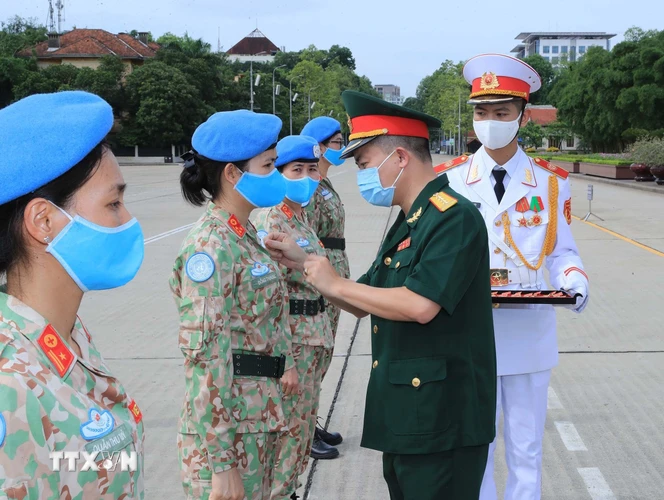 Tặng Huy hiệu Bác Hồ cho các sỹ quan của Bệnh viện dã chiến cấp 2 số 2 và sỹ quan hoạt động độc lập tại lễ báo công. (Ảnh: Trọng Đức/TTXVN)