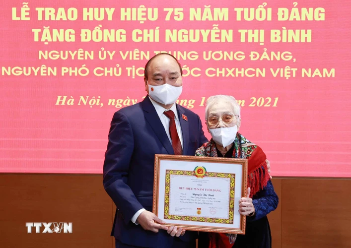 Chủ tịch nước Nguyễn Xuân Phúc trao tặng huy hiệu 75 năm tuổi Đảng cho bà Nguyễn Thị Bình, nguyên Phó Chủ tịch nước CHXHCN Việt Nam. (Ảnh: Thống Nhất/TTXVN)