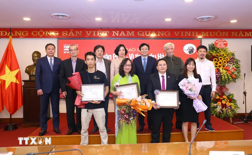 Phó Chủ tịch Thường trực Ủy ban Nhân dân thành phố Hà Nội Lê Hồng Sơn và Tổng Giám đốc TTXVN Vũ Việt Trang cùng các tác giả đoạt giải. (Ảnh: Hoàng Hiếu/TTXVN)